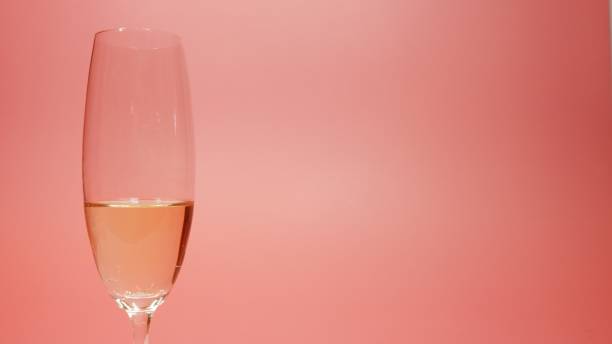 istock Champagne glass against pink background with copy space for title 1401699410