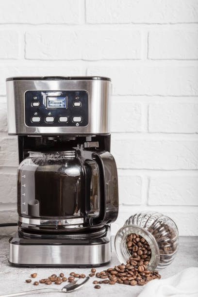 istock Drip coffee maker and white cup. Household appliances on the kitchen table. Preparing hot coffee in a coffee machine 1401708992