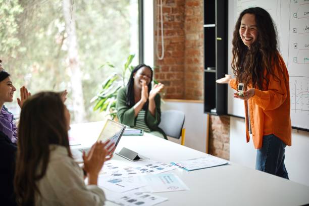 female entrepreneur giving presentation over whiteboard during meeting in office - 市場推銷 圖片 個照片及圖片檔