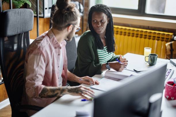istock Multi-ethnic business professionals discussing at desk 1401713181