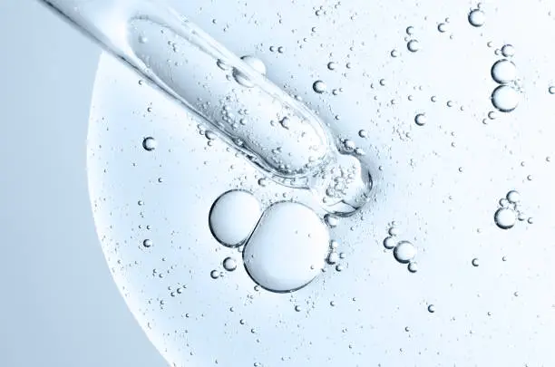 The texture of a cosmetic serum with a pipette closeup. Macrophotography.