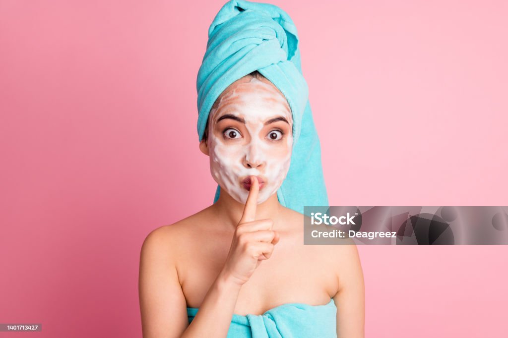 Photo of charming pretty young woman cover finger lips wear blue turban towel isolated on pastel pink color background Photo of charming pretty young woman cover finger lips wear blue turban towel isolated on pastel pink color background. Adult Stock Photo