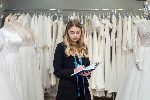 istock pretty young saleswoman hold notes diary in modern wedding store 1401715273