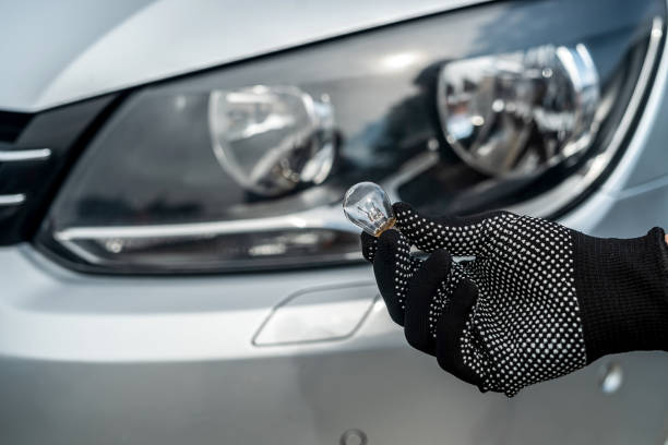 istock mechanic change low-beam or high-beam light bulb in his car 1401715305