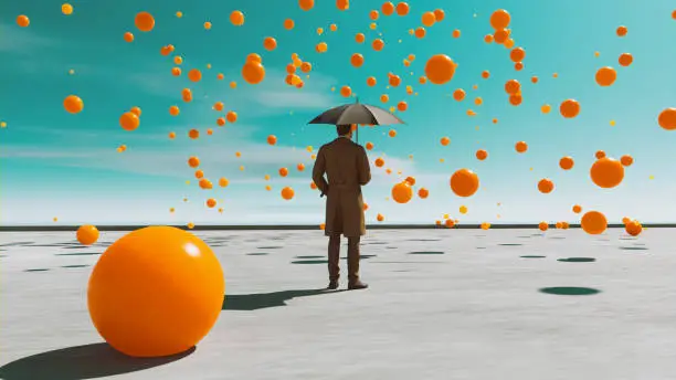 Photo of Orange balls fall from the sky while man with umbrealla looks at them