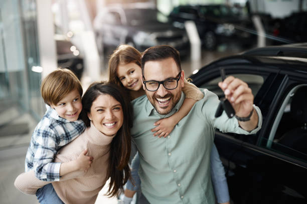 glückliches familienhuckepack nach dem kauf eines neuen autos in einem ausstellungsraum. - car car rental car dealership key stock-fotos und bilder