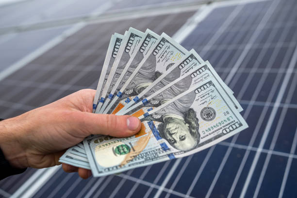 beautiful young gorgeous worker hands holding round sum of money for installing solar panels. stock photo