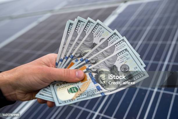 Beautiful Young Gorgeous Worker Hands Holding Round Sum Of Money For Installing Solar Panels Stock Photo - Download Image Now