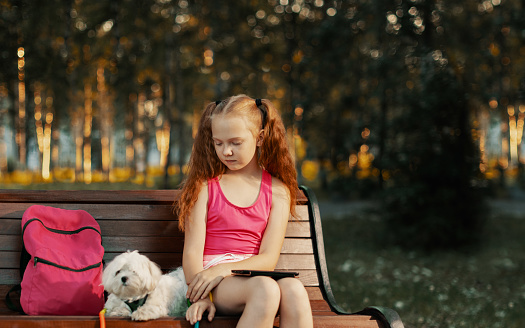 Girl sitting on park bench in evening.