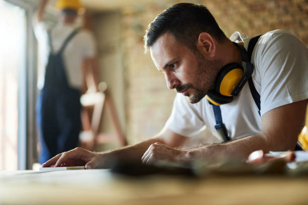 istock Young male carpenter working at construction site. 1401717307