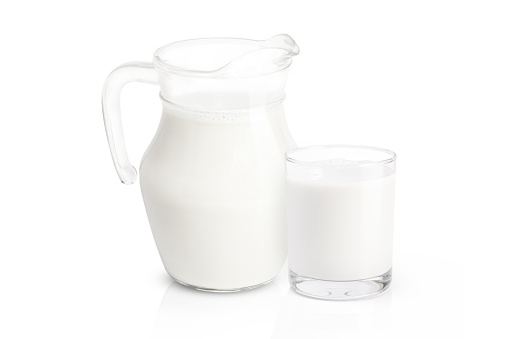 Fresh milk in glass jug isolated on white background .