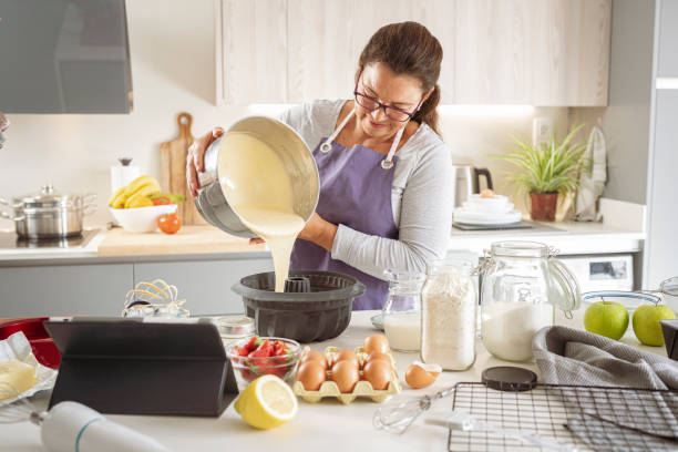 istock Woman pouring cream in a cake baking form 1401722108