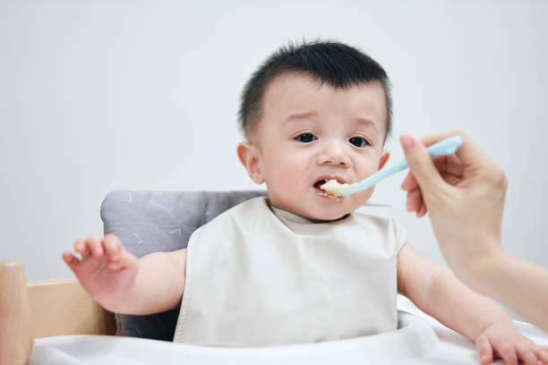 istock Asian baby boy upset while being fed by spoon 1401722922