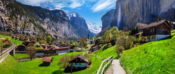 Switzerland nature and travel. Alpine scenery. Scenic traditional mountain village lauterbrunnen with waterfall  surrounded by snow peaks of Alps. Popular tourist destination and ski resort stock photo