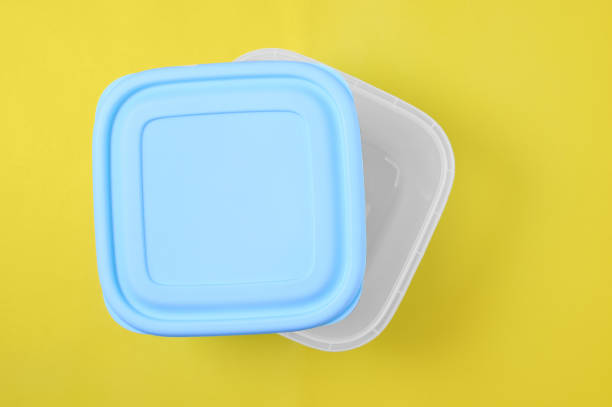 Plastic container with  lid for food. Yellow background.