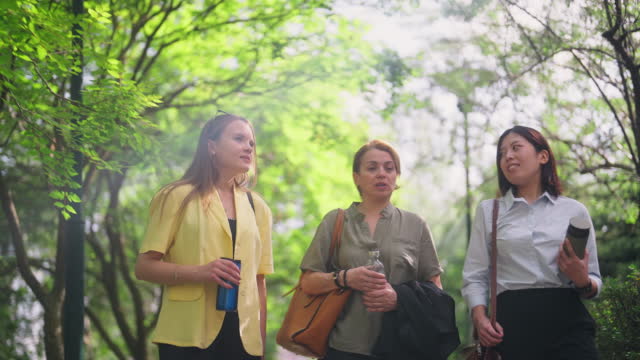 Three multi-ethnic businesswomen spending their break time in public park