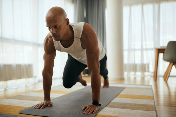 istock Young African American athletic man doing running plank exercise while working out at home. 1401728505