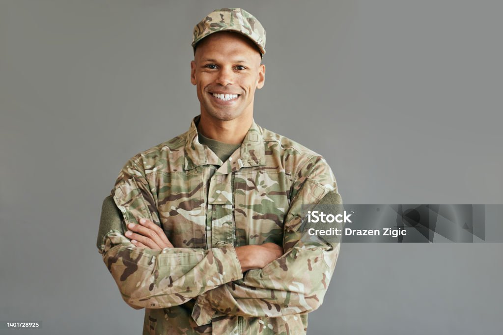 Young confident African American veteran looking at camera. Portrait of happy African American soldier standing with arms crossed and looking at camera. Copy space. Military Stock Photo