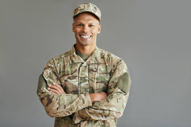 Young confident African American veteran looking at camera. Portrait of happy African American soldier standing with arms crossed and looking at camera. Copy space. national guard stock pictures, royalty-free photos & images