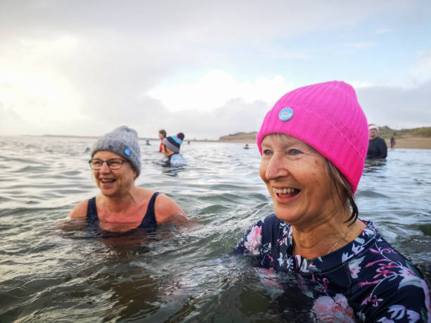 Bluetits Chill Swimmers - ladies cold water swimming Burry Port, Wales, UK: December 26, 2021: A group of mature female friends swimming in the sea. The Bluetits Chill Swimmers Ltd is a social enterprise committed to empowering our inclusive community of outdoor dippers. woman cold water swimming stock pictures, royalty-free photos & images
