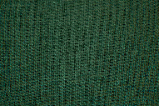 Textured background from natural linen fabric, green colour.