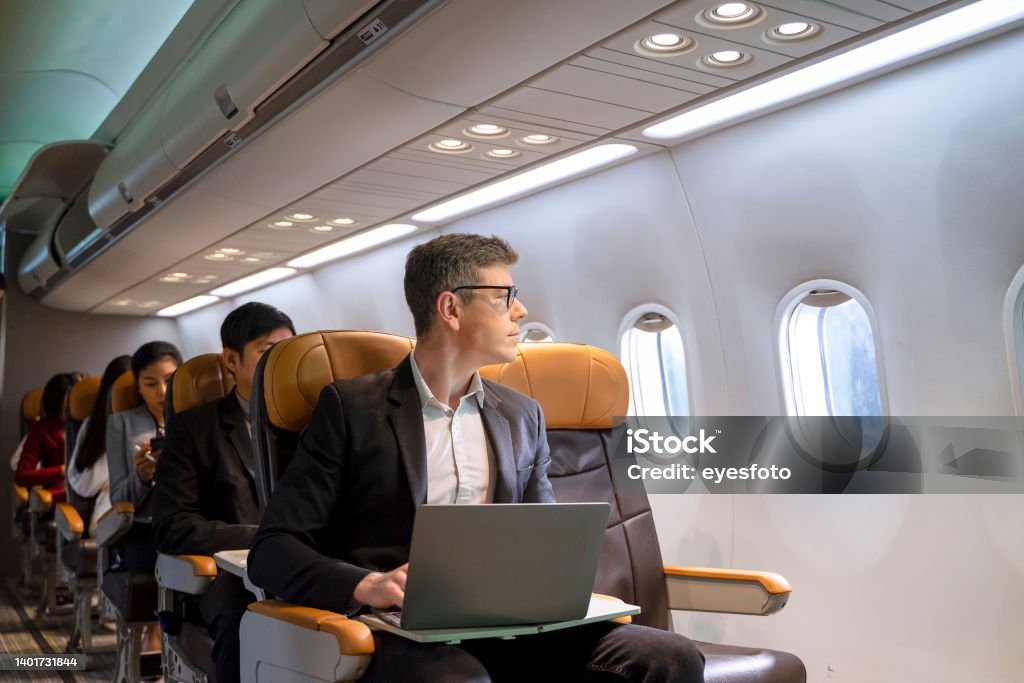 Passengers are sitting in the commercial plane. Passengers are sitting in the commercial plane. Cabin crew is take care passengers in the plane. Jouney with commercial plane. Airplane Stock Photo