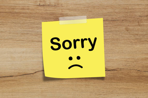 istock Yellow sticky note with inscrition SORRY on wooden table 1401734393