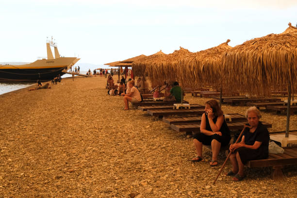 People gather on the beach during a wildfire at Pefki village on Evia island, about 189 kilometers (118 miles) north of Athens, Greece, Aug. 8, 2021.