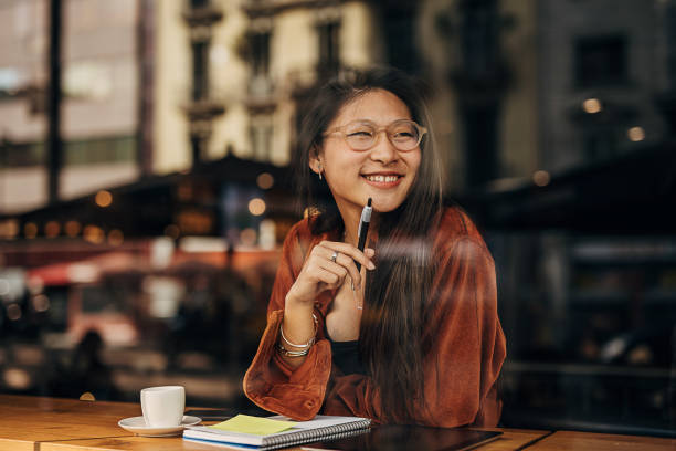 istock Asian woman sitting in the cafe and writing notes while being on the coffee break 1401739014