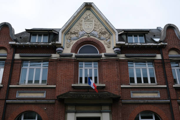 A flag of French Republic waves outside of a building A flag of French Republic waves outside of a building in Lens, France on February 2, 2022. lens pas de calais stock pictures, royalty-free photos & images