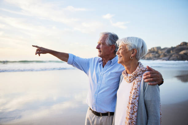 istock Senior couple looking out at the ocean view while standing on a beach 1401740002