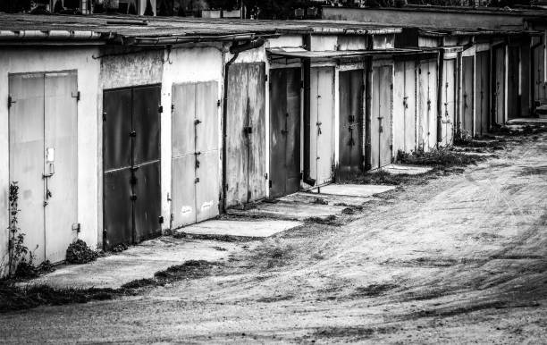 Row of garages for rent with different doors, black and white image