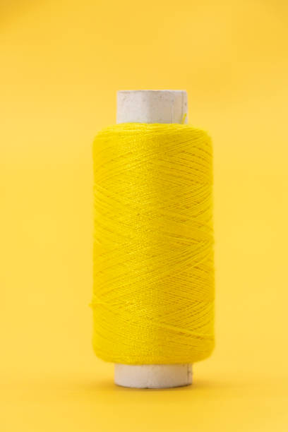 yellow color yarn or spool thread over on yellow background stock photo