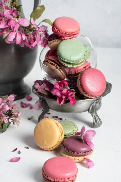 istock spring still life with colored macaroons and pink apple tree flowers in a pewter 1401741438