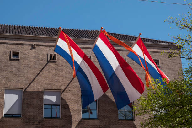 three times a Dutch flag in red white blue with an orange ribbon to indicate that it is someone from the royal family's birthday