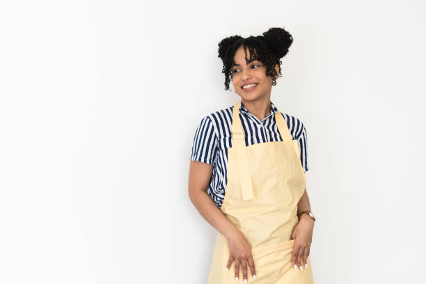 Studio portrait of a beautiful, happy young woman with apron