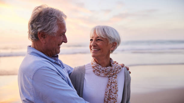 istock Senior woman standing with her husband on a beach and smiling 1401744578