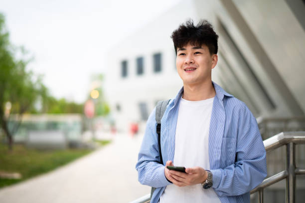 istock Asian young handsome man using smartphone at subway station 1401744642