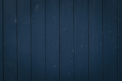 Close-up on a dirty blue wooden fence.