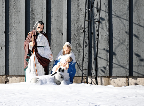 Mary, Joseph, and Baby Jesus statues in the snow.