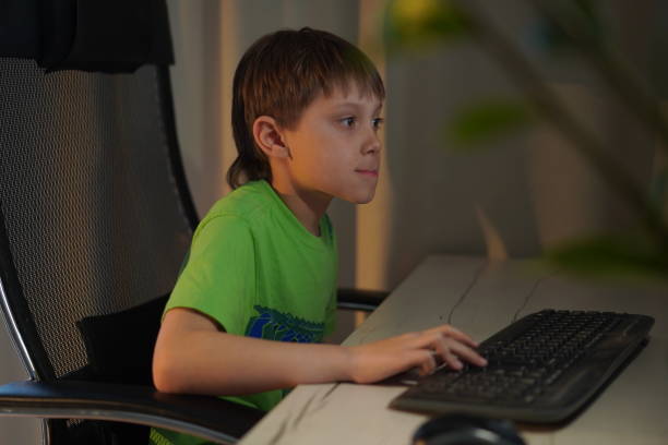 istock Cute caucasian boy playing video game at desktop computer at home 1401745089