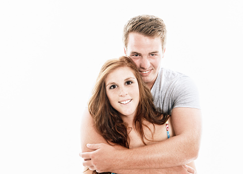 Shot in high key, a good-looking young couple beam happily at the camera.