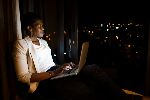 African businesswoman working at night in luxury hotel room