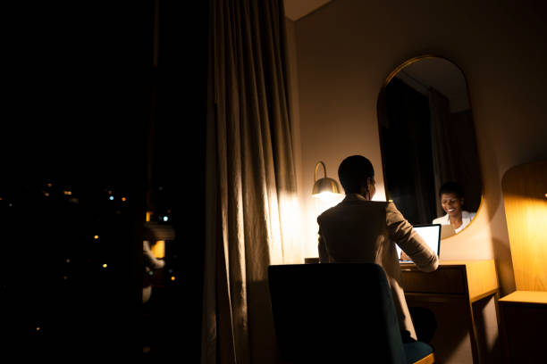 istock Back view businesswoman using laptop reflected in mirror 1401750517