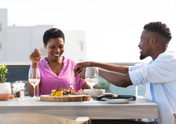 istock Couple sharing food at a rooftop cafe 1401750733