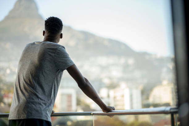 istock Back view man standing on balcony looking a cityscape 1401750798