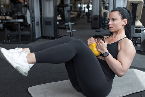 istock Woman doing abs workout by kettlebell in gym 1401751775