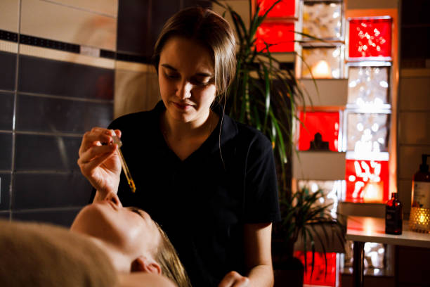 istock Masseur doing face massage with cream to lady on couch 1401752146