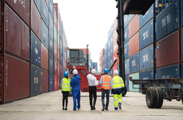istock Dock manager and engineer worker discuss on quality at container shipping yard during truck lifting cargo box. Import and export product. Manufacturing transportation and global business concept 1401753223