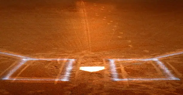 Baseball homeplate with batter box chalk lines in brown clay dirt